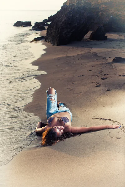 Женщина на пляже в джинсах — стоковое фото
