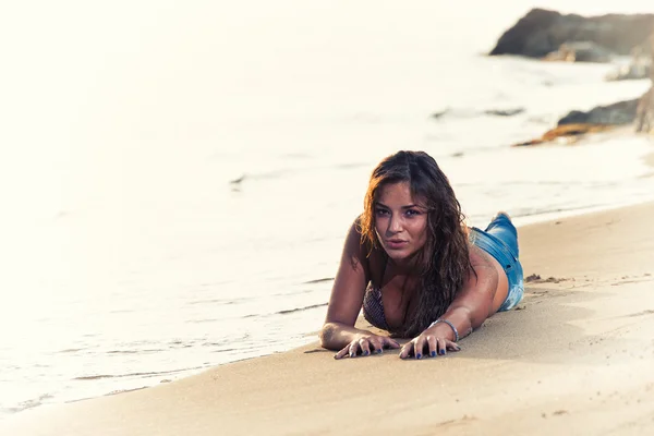 Kvinna på stranden i jeans — Stockfoto
