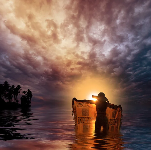 Jonge vrouw op het strand bij zonsondergang — Stockfoto