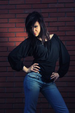 tuğla duvarın önünde genç bir kadın