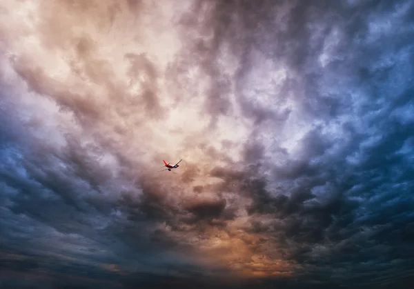 Airplane over dramatic sky — Stock Photo, Image