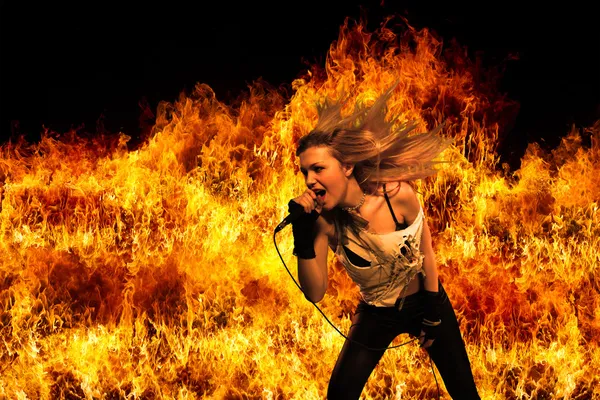 Cantora de rock feminina sobre chamas ardentes — Fotografia de Stock