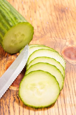 büyük bir ahşap masa dilimlenmiş salatalık