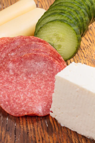 Feta and ementhal cheese with salami and cucumber — Stock Photo, Image