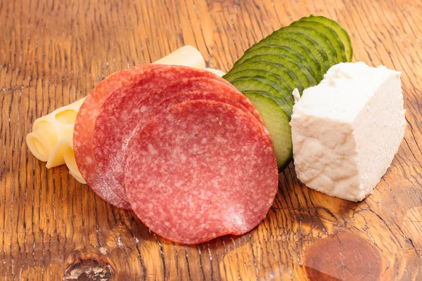 Feta and ementhal cheese with salami and cucumber — Stock Photo, Image