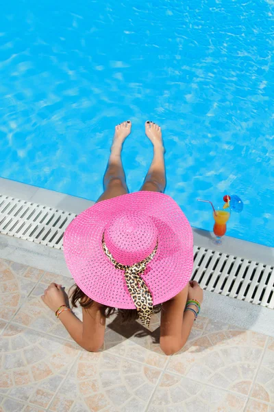 Mujer sentada en la repisa de la piscina . — Foto de Stock