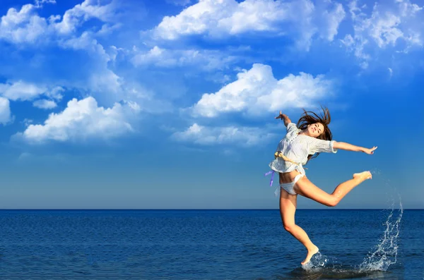 Schönes Mädchen, das anmutig am Strand springt — Stockfoto