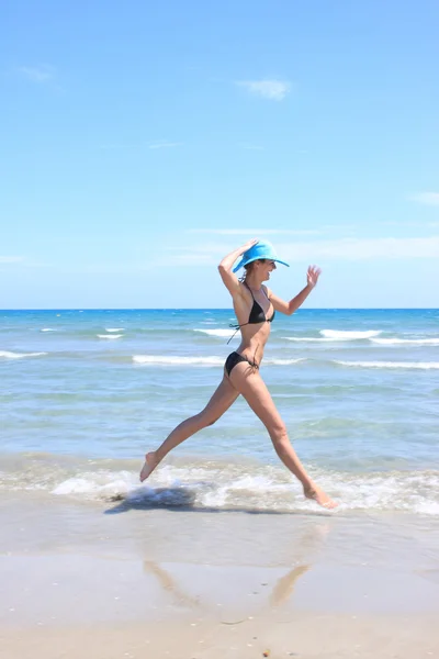 Jovem mulher de pé em uma praia — Fotografia de Stock