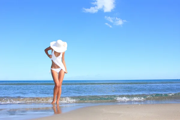 Giovane donna in piedi su una spiaggia — Foto Stock