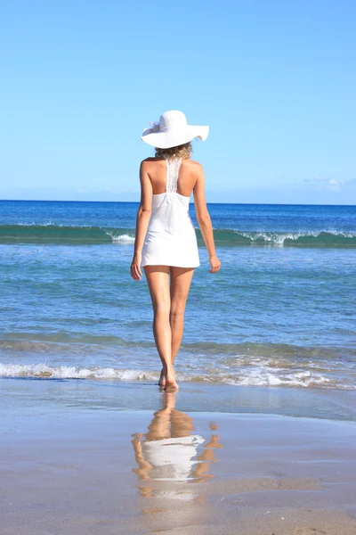 Jonge vrouw permanent op een strand — Stockfoto