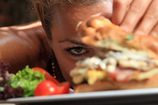 Einen leckeren Cheeseburger essen — Stockfoto