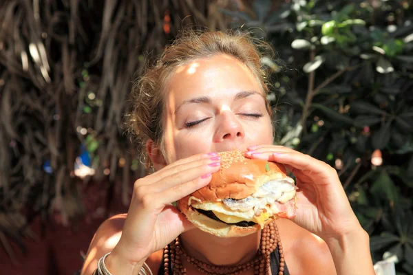 女人吃芝士汉堡 — 图库照片