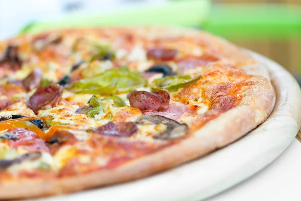 Pizza feita com salame, mussarela, cogumelos, azeitonas — Fotografia de Stock