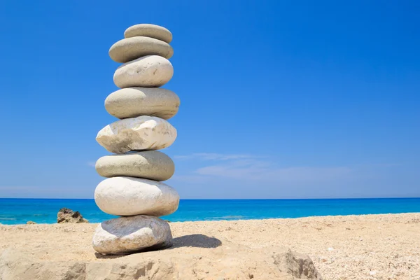 Камінці укладають баланс над синім морем — стокове фото