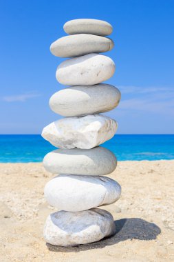 Pebbles stack balance over blue sea