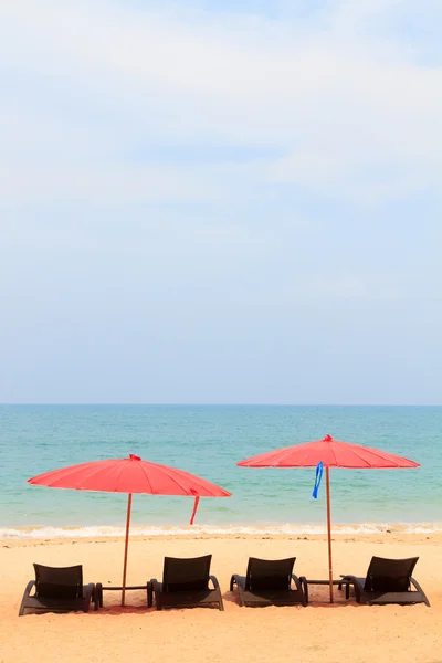 Camas y sombrillas en una playa — Foto de Stock