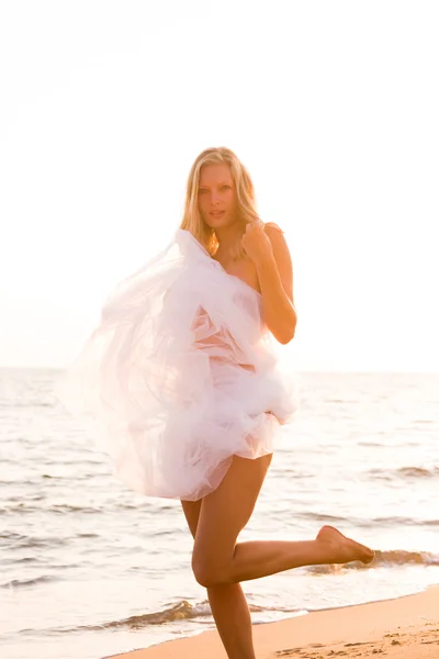 Kvinna insvept i bröllop slöja på stranden — Stockfoto
