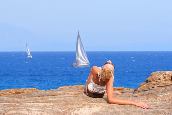 Mujer relajándose por la tarde junto al mar — Foto de Stock