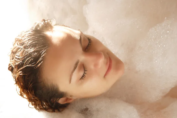 Молодая женщина наслаждается пеной для ванны — стоковое фото