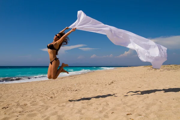 Meisje met witte sarong op het strand. — Stockfoto