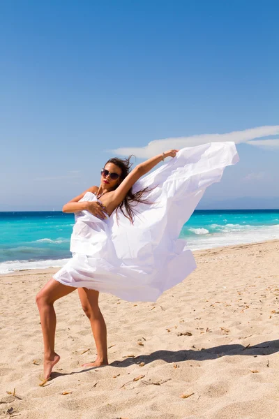 Meisje met witte sarong op het strand. — Stockfoto