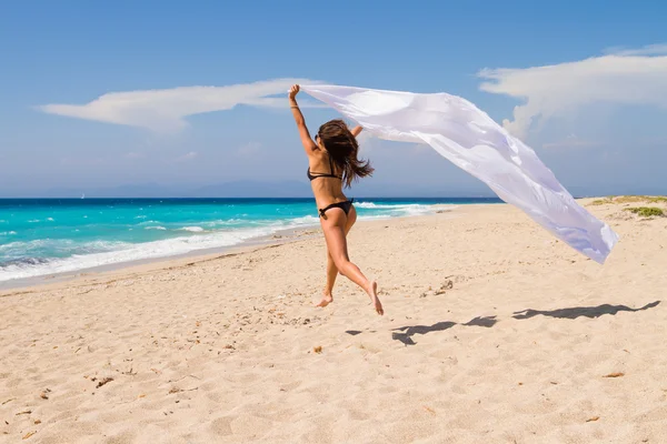 Menina bonita com tecido branco na praia . — Fotografia de Stock