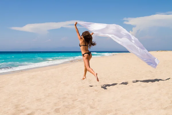 Bella ragazza con tessuto bianco sulla spiaggia . — Foto Stock