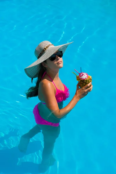 Vrouw met verse cocktail in het zwembad — Stockfoto