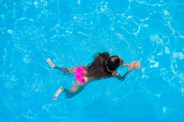 Bir kızın rahatlatıcı bir yüzme havuzunda — Stok fotoğraf