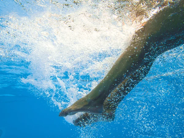 Ung kvinna simning undewater — Stockfoto
