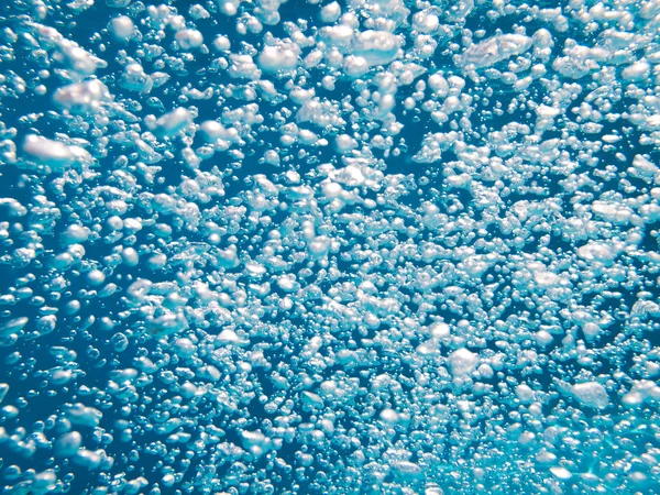 Bubbels in helder blauw water — Stockfoto