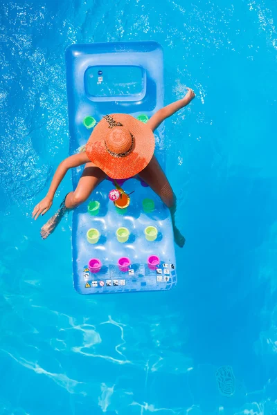Ung kvinna på en lilo i poolen — Stockfoto