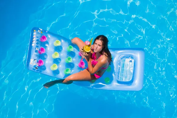 Une fille se relaxe dans une piscine — Photo