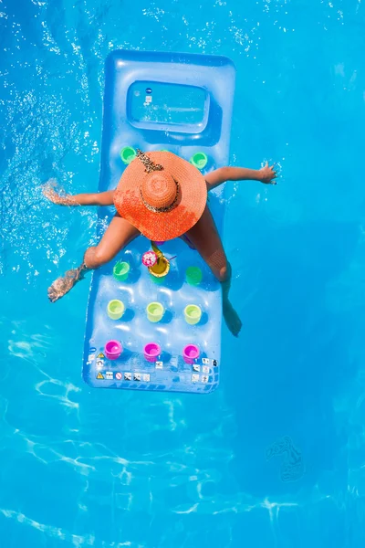 Mujer joven en un lilo en la piscina — Foto de Stock