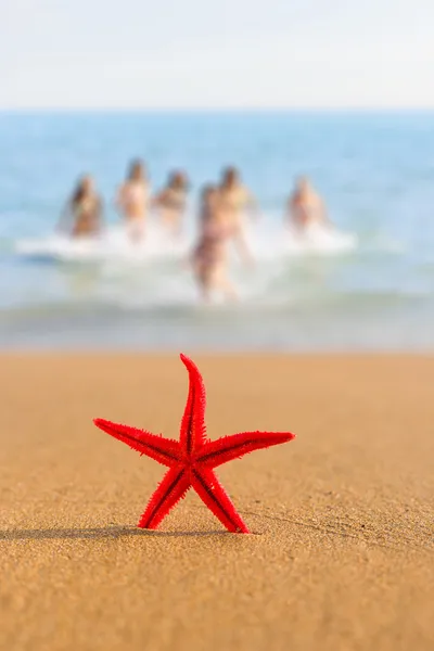 Étoile de mer sur la plage au lever du soleil avec des filles sur BG — Photo