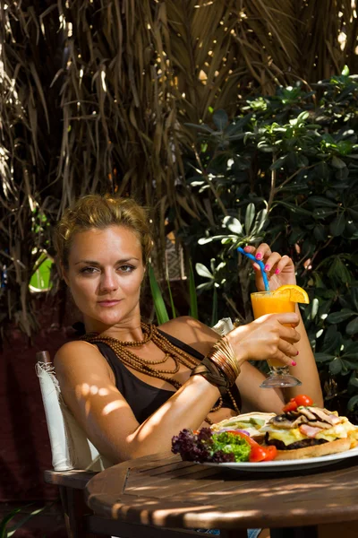 Mulher comendo um cheeseburger — Fotografia de Stock