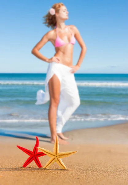 Estrella de mar y mujer joven en la playa —  Fotos de Stock