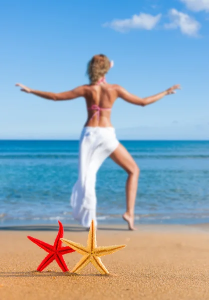 Hvězdice a mladá žena na pláži — Stock fotografie
