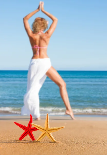 Морская звезда и молодая женщина на пляже — стоковое фото
