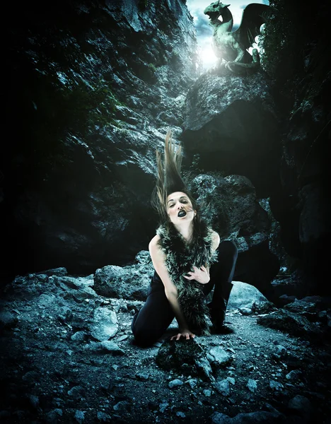 Woman with dragon in a cave — Stock Photo, Image