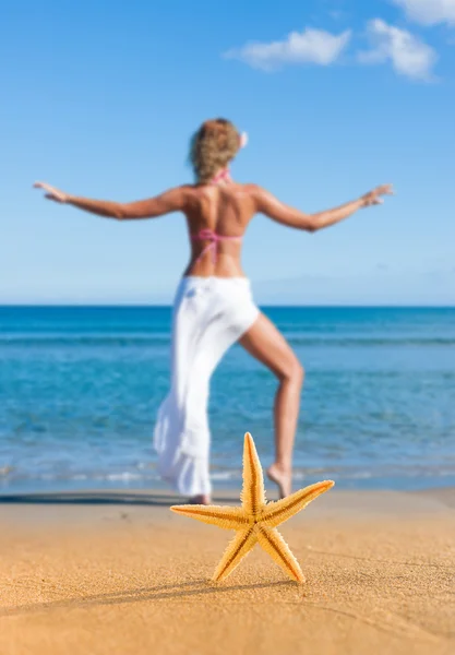 Rozgwiazdy i młoda kobieta na plaży — Zdjęcie stockowe