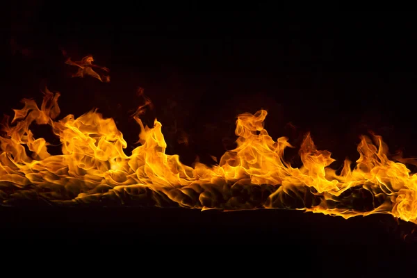 Пылающий огонь на черном фоне — стоковое фото