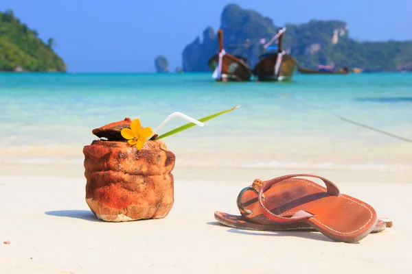 Kokos koktajl z picia słomy i sandały — Zdjęcie stockowe
