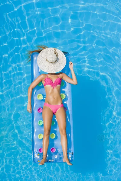 Uma menina está relaxando em uma piscina — Fotografia de Stock