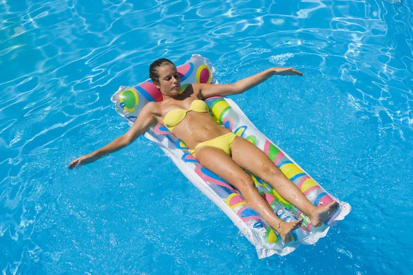 Uma menina está relaxando em uma piscina — Fotografia de Stock