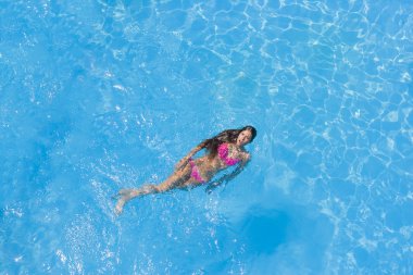 bir kızın rahatlatıcı bir yüzme havuzunda