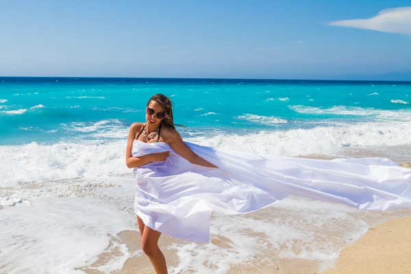 Menina bonita com tecido branco na praia . — Fotografia de Stock