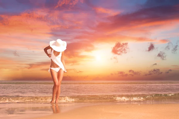 Vrouw op het strand bij zonsondergang — Stockfoto