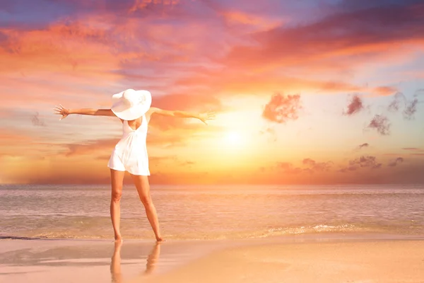 Kobieta na plaży o zachodzie słońca — Zdjęcie stockowe