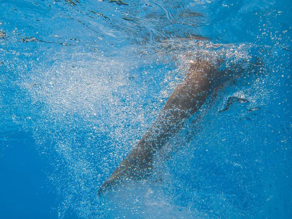 Mladá žena nohy undewater v bazénu — Stock fotografie